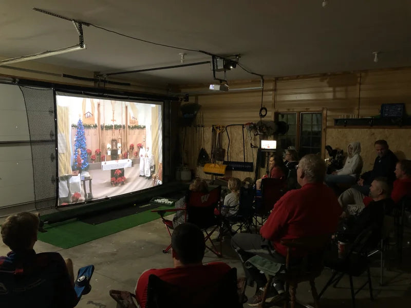 G-Trak retractable screen in garage with movie on screen