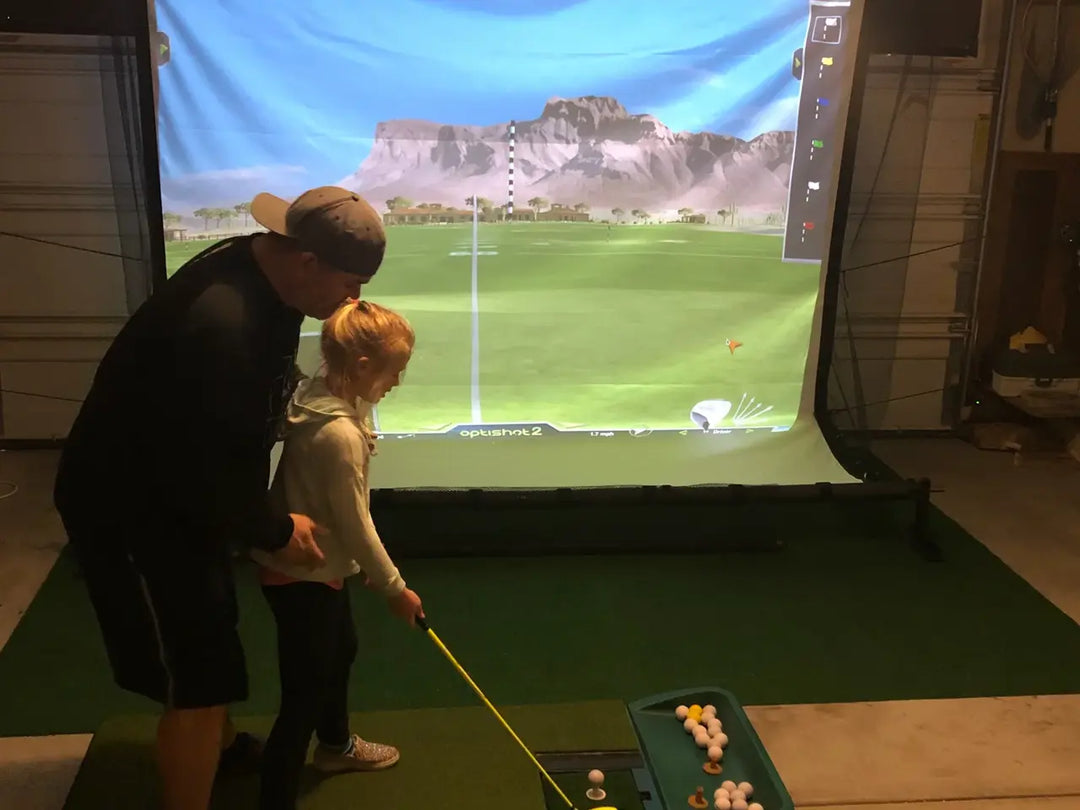 G-Trak founder using golf simulator on retractable screen 